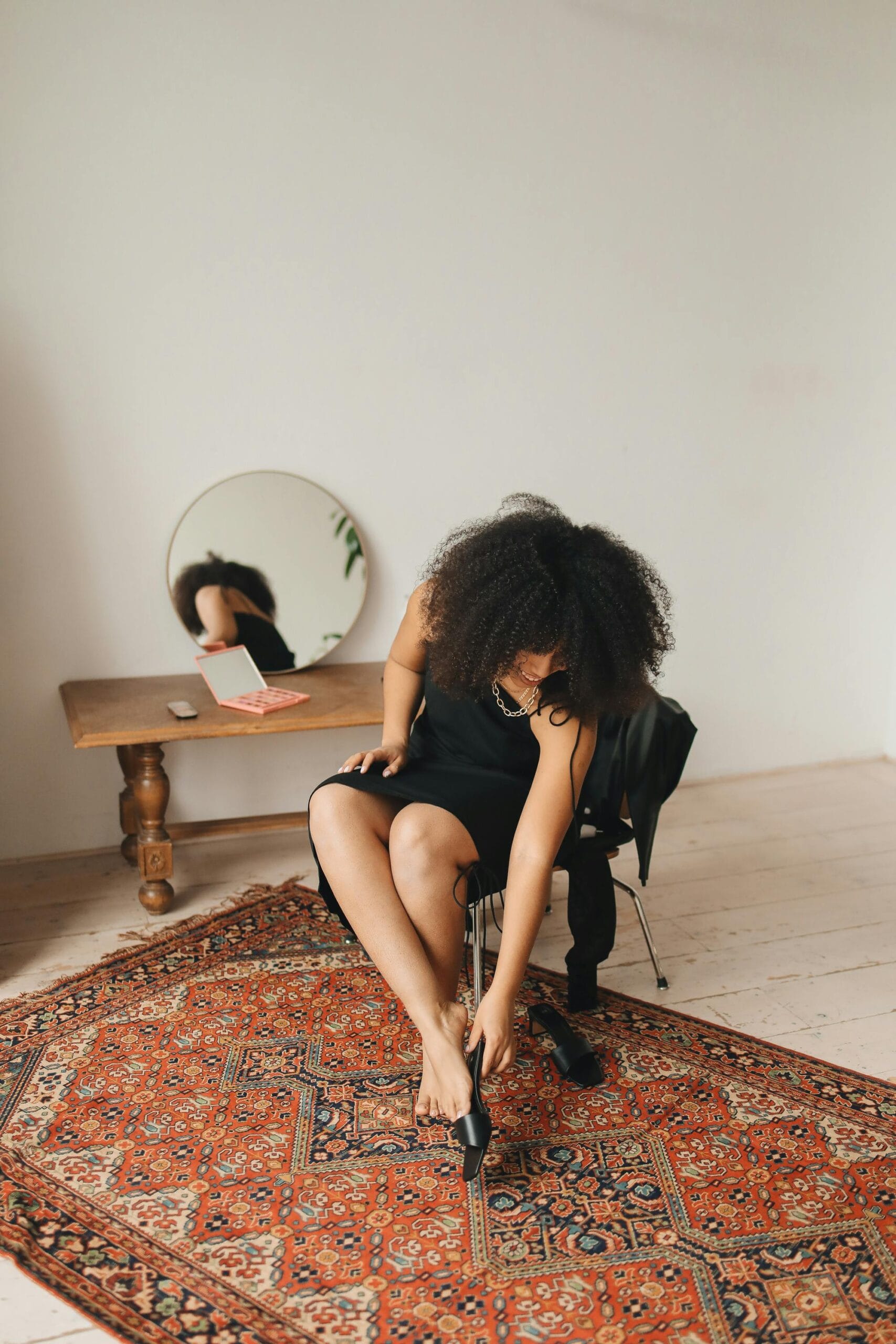 Stylish woman adjusting heels at home — freshwater pearls are real pearls, just like natural beauty