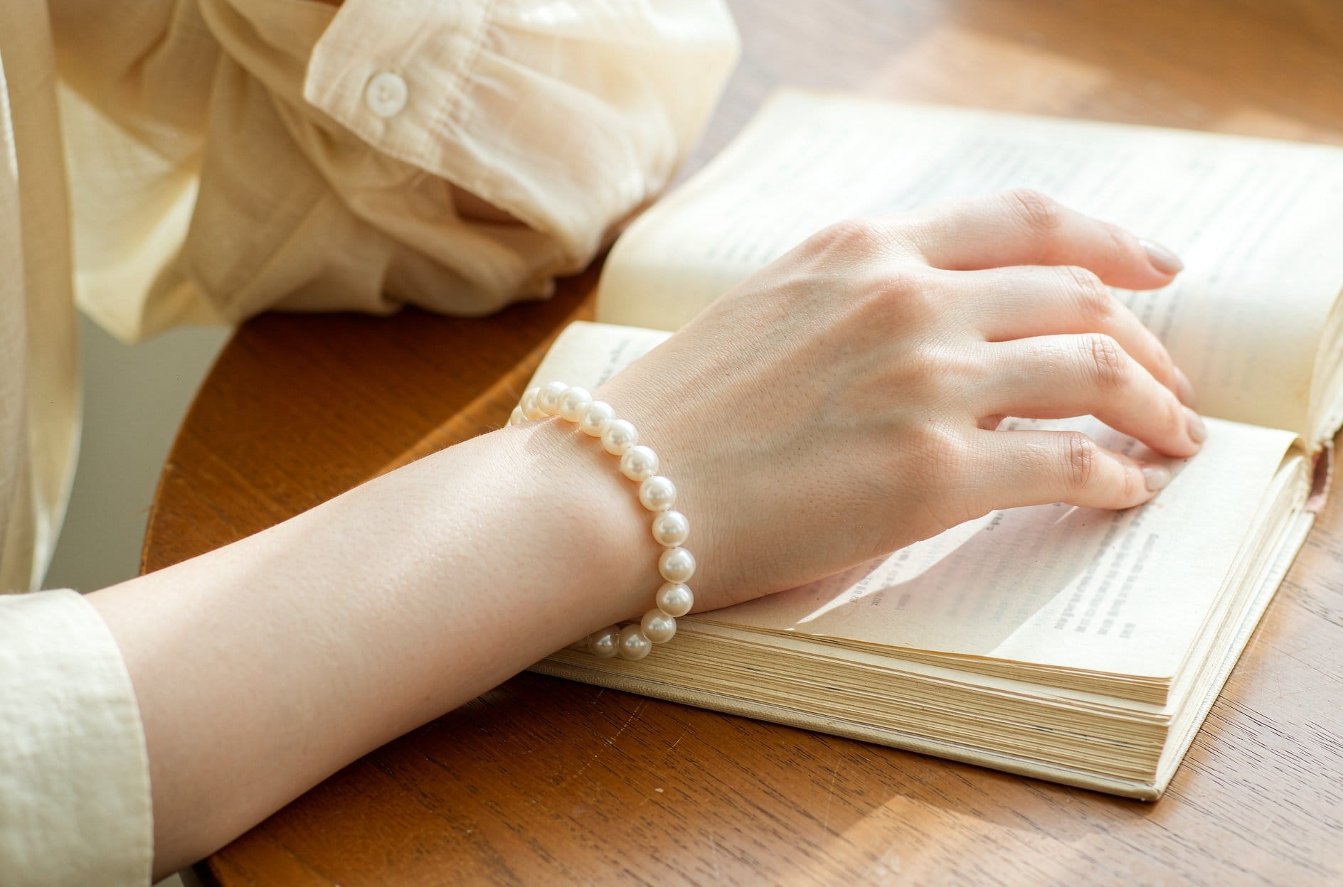 Hand holding a baroque pearl up to the light to check luster before buying a pearl gift for girlfriend