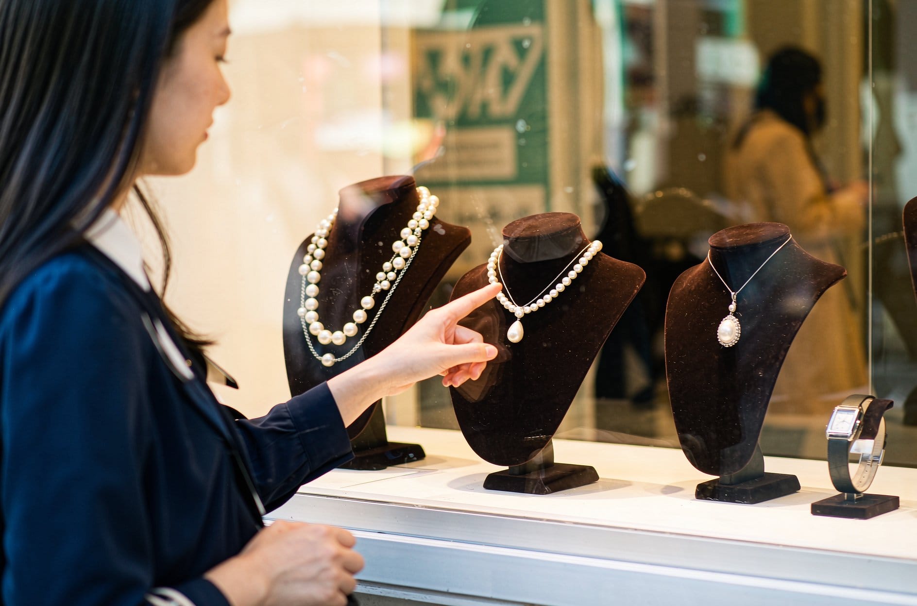 Pearl bracelet on a wrist over an open book: a timeless pearl gift for girlfriend idea